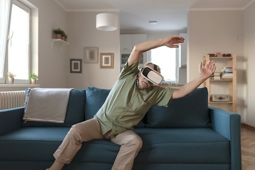 Alter Mann macht Gymnastikübungen mit VR-Brille