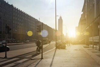 Radfahrer im Straßenverkehr bei Sonnenuntergang