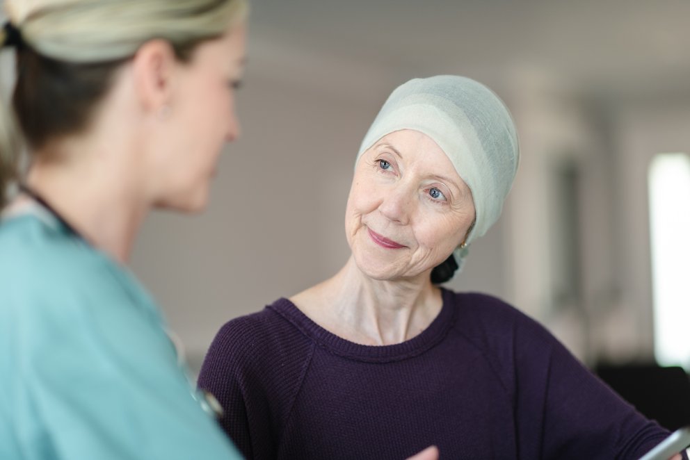 Das Bild zeigt eine Pflegerin mit einer Krebspatientin.